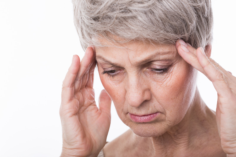 depression Eine Frau hält sich die Schläfen vor Schmerz